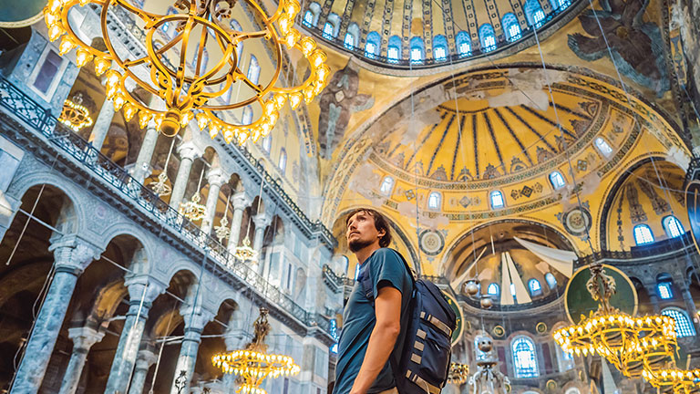 Downloaded Man tourist enjoying Hagia Sofia, Ayasofya interior in Istanbul, Turkey, Byzantine architecture, city landmark and architectural world wonder. Turkiye by galitskaya