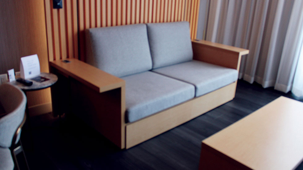 This space-saving sofa’s armrests double as tables with power ports.  Photo by Andrea M. Corbin