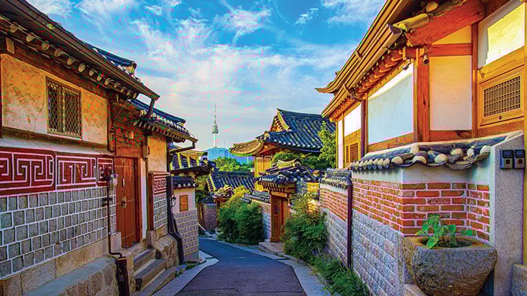 Centuries-old Bukchon Hanok Village is shown with N Seoul Tower, Korea’s modern-day symbol, visible in the distance; Photo by Phuaorneer/stock.adobe.com