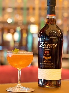 Old Cuban mix drink next to a bottle