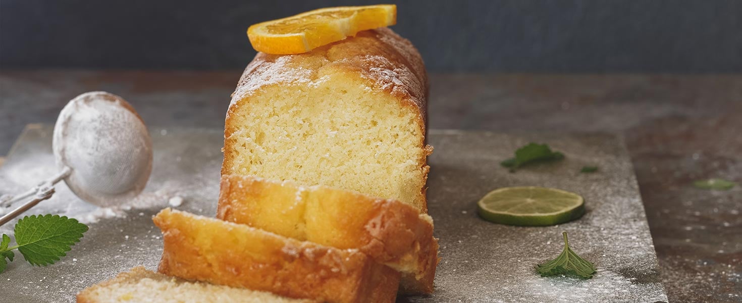 Sicilian orange cake partly sliced and fresh fruits.