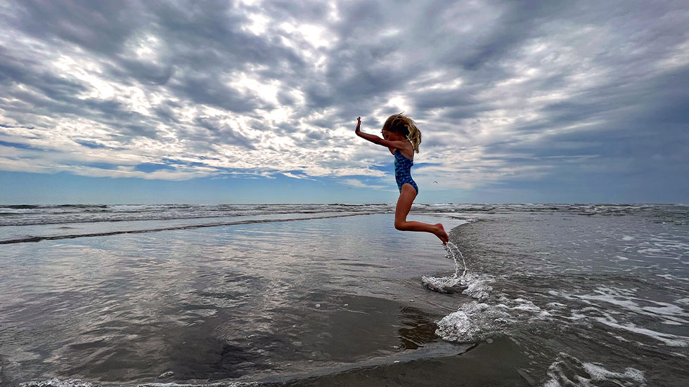 Little girl jumping at Jersey Shore in Ocean City, NJ.