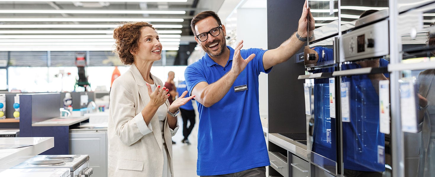 Salesperson assisting customer in modern appliance store