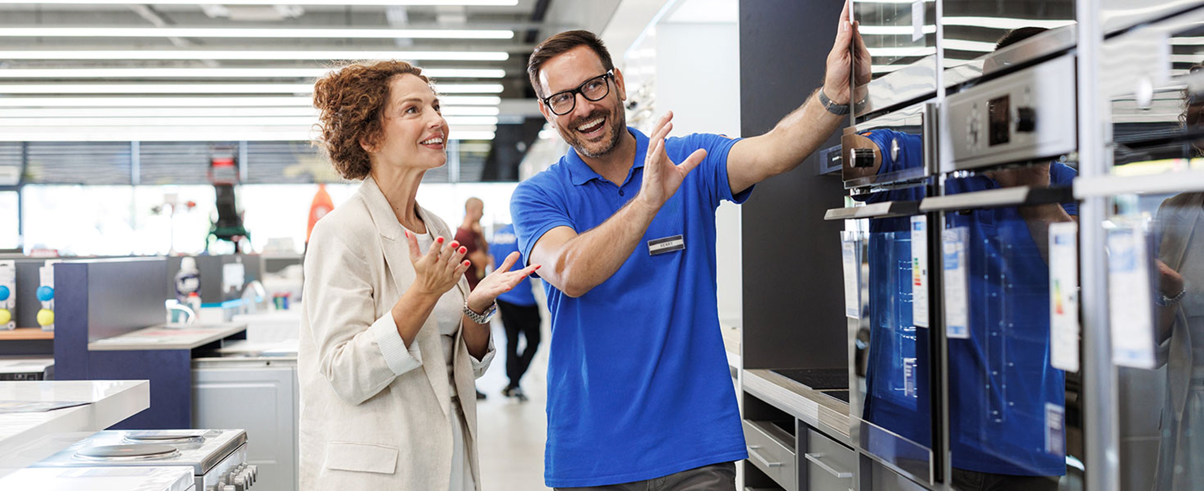 Salesperson assisting customer in modern appliance store