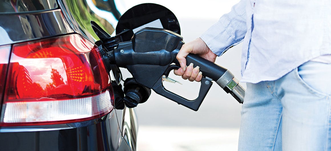 man pumping gas, holding gas nozzle