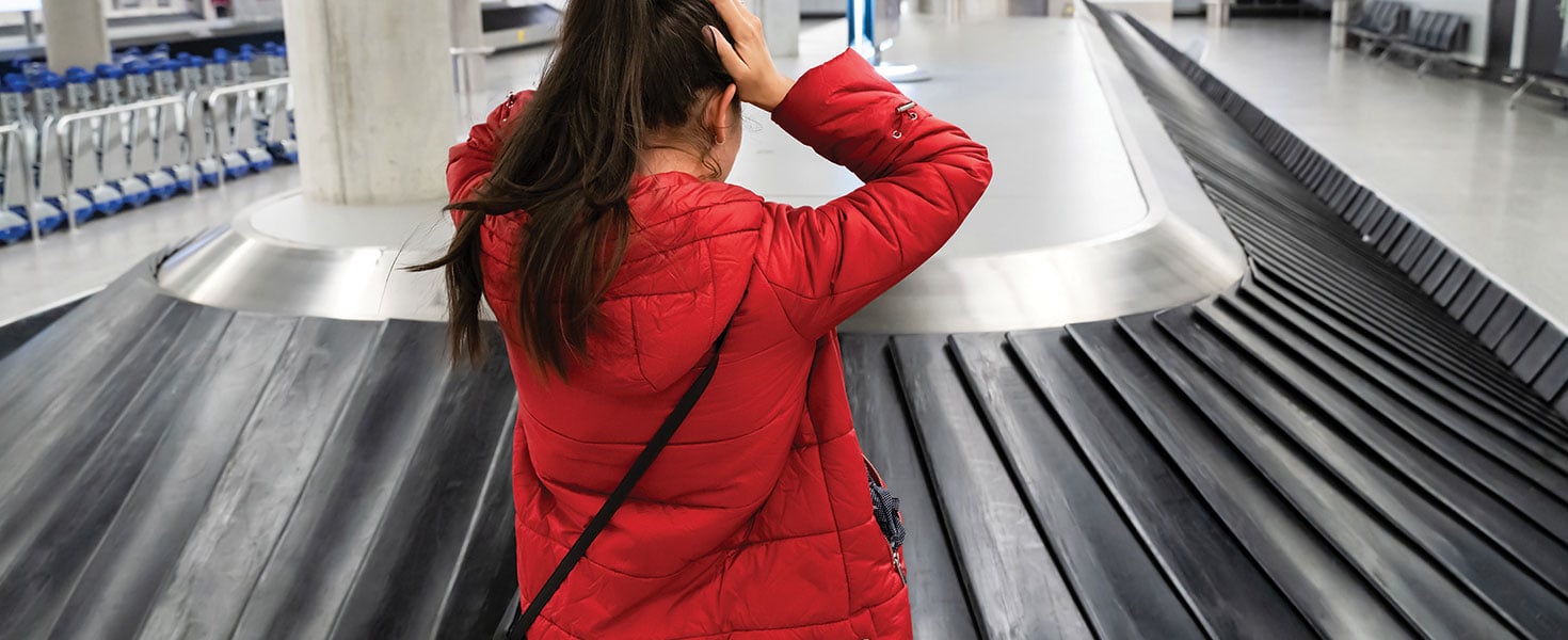 woman in red jacket can't find her luggage