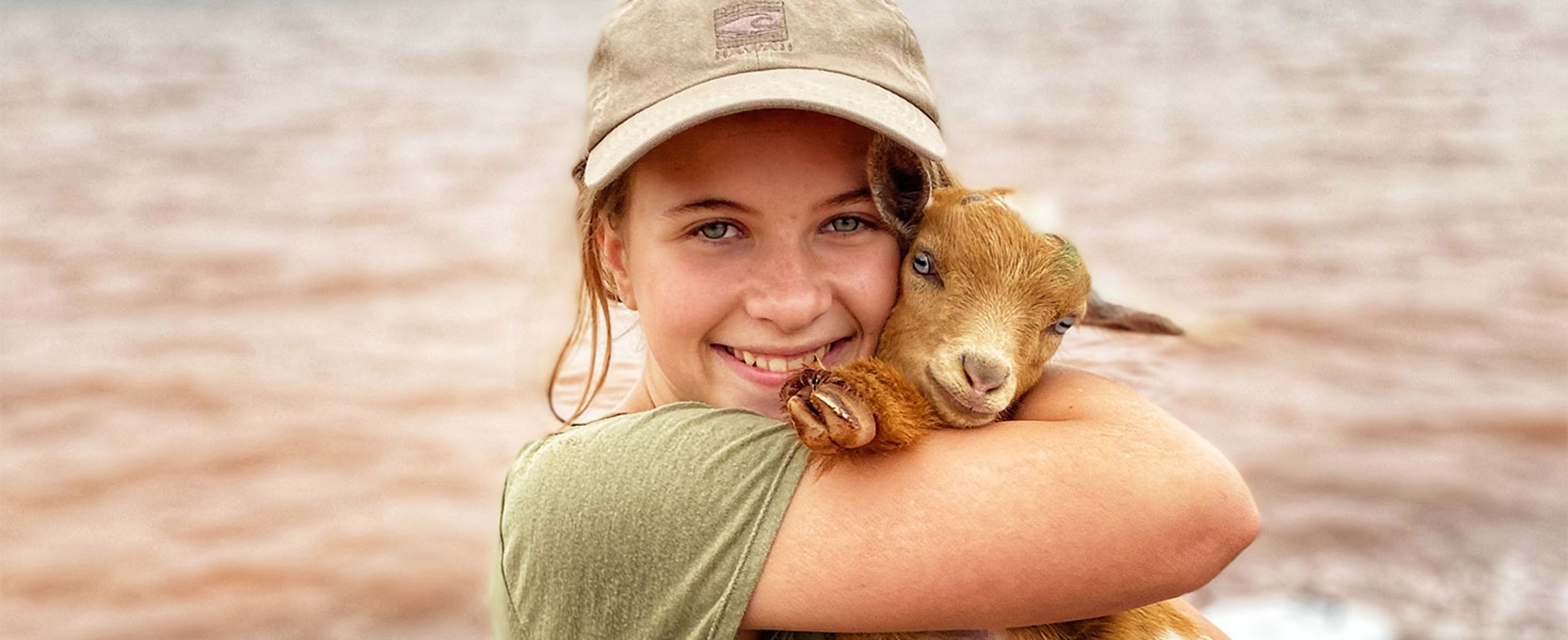 girl cuddling a goat