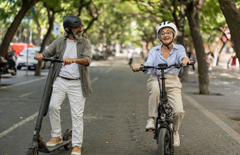 man and woman riding ebike and e scooter on street