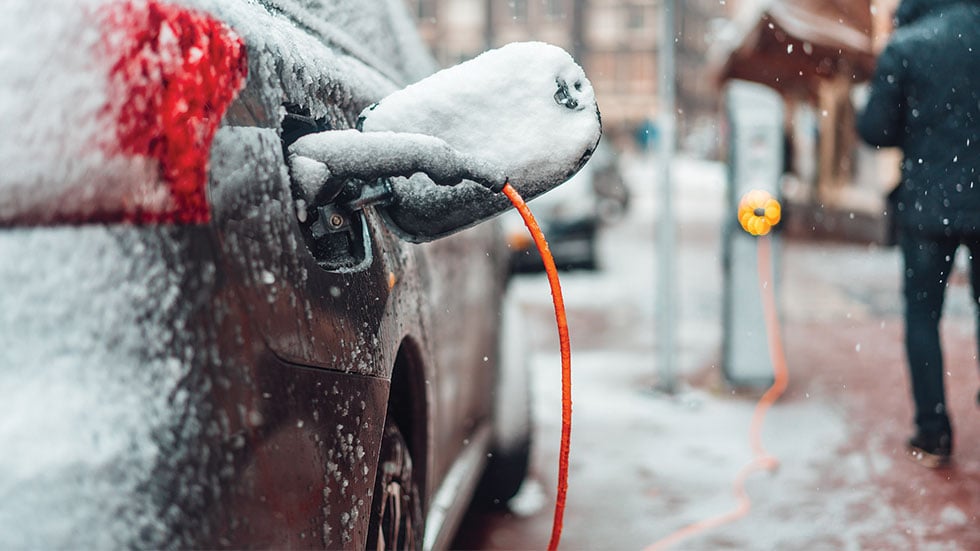 electric vehicle being charged in the snow