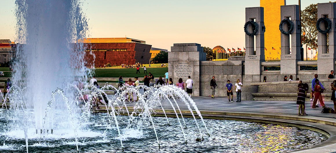 The World War II Memorial, with the Washington Monument and the National Museum of African American History AAA.com/The-Extra-Mile-Magazine and Culture seen in the background