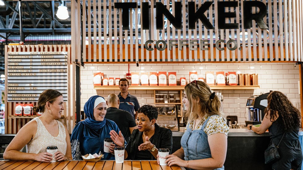 Goupr of people gathered at table with drinks