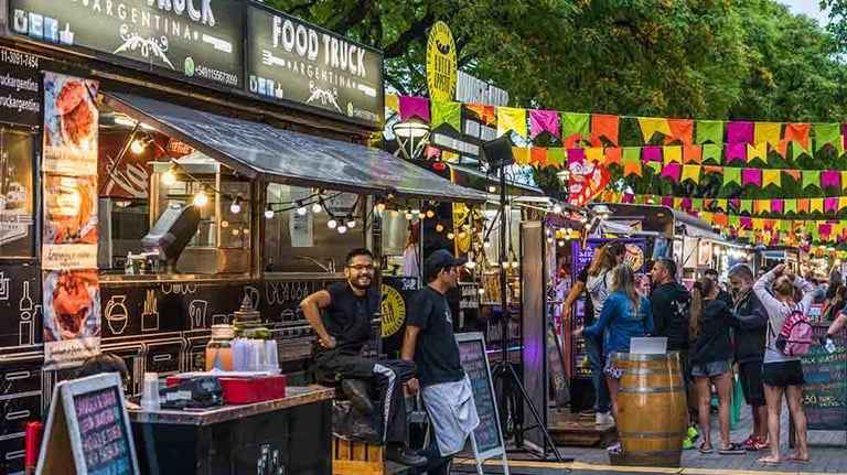 Food trucks and people at a street food market festival on a sunny day