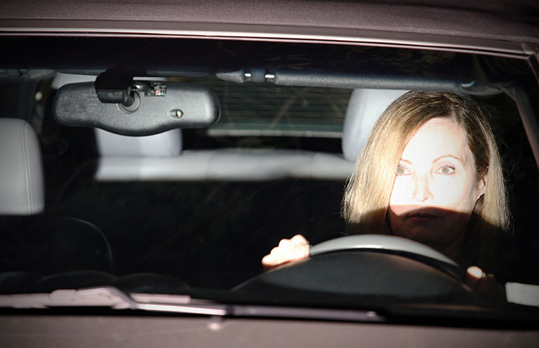 headlight glaring on woman driver