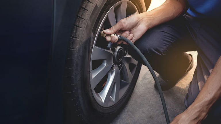 Man filling Air into the Tire. Car Driver Checking Air Pressure and Maintenance his Car by himself before Traveling. PHOTO BY BLACKSALMON/STOCK.ADOBE.COM 