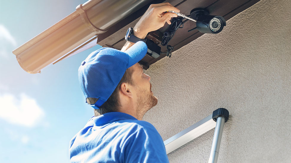 Man installing home security camera