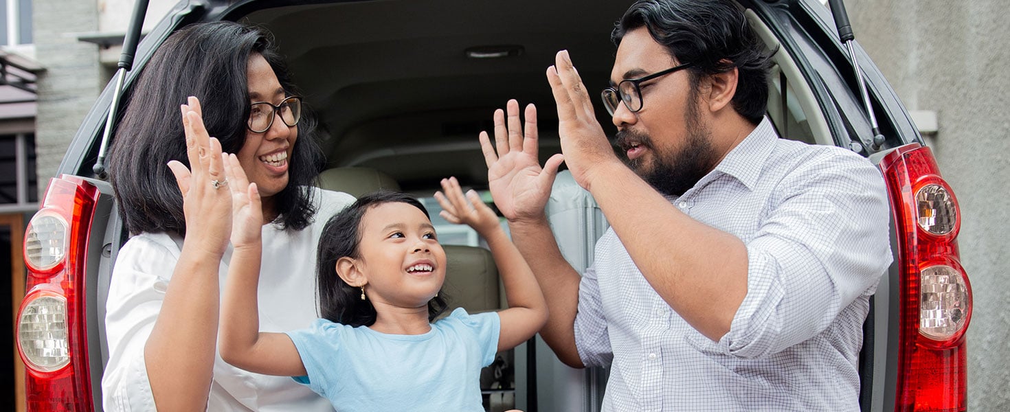 family on back of car ready for vacation