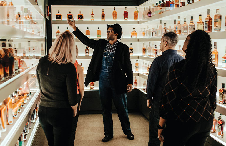 A tour guide gives Frazier History Museum visitors details about Kentucky bourbon
