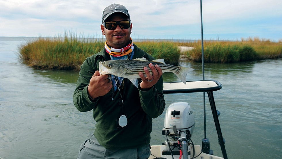 man showing off stripped bass