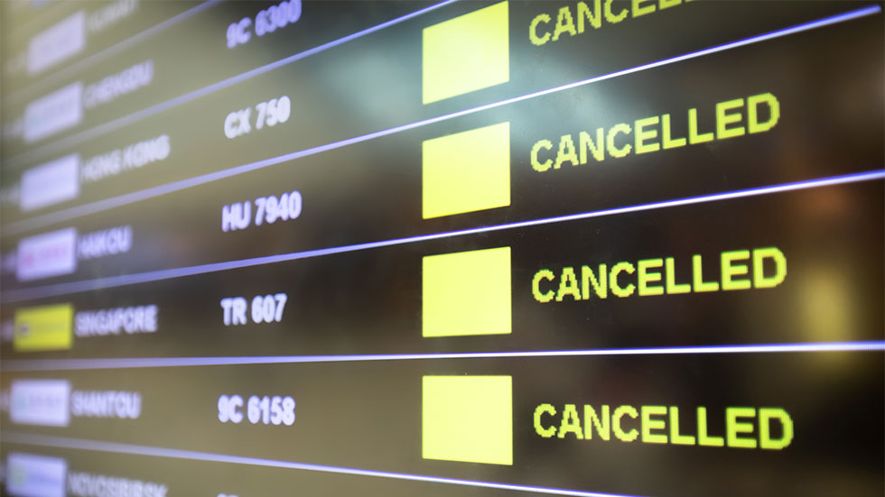 screen at airport showing list of cancelled flights