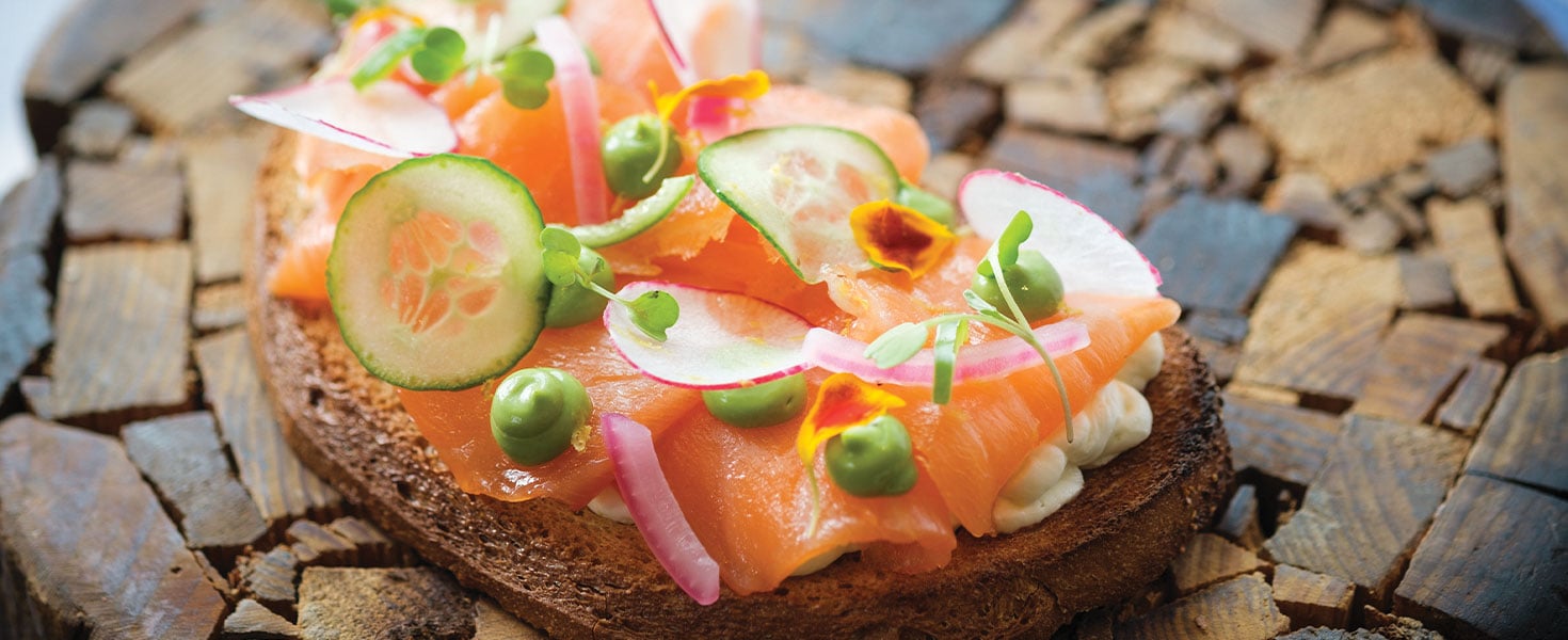 toast with cucumbers and tomatoes on firewood plating