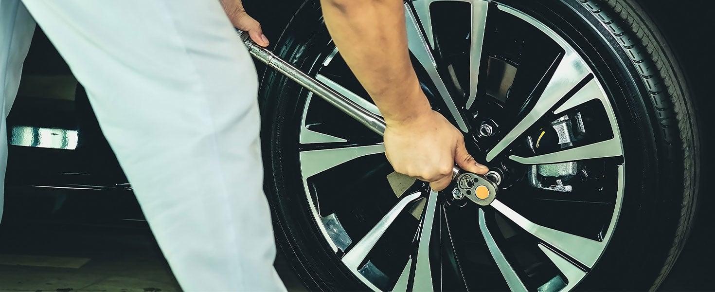 Person using torque wrench socket on car wheel lug nuts