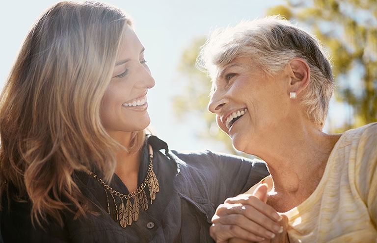 woman and elder woman laughing outside