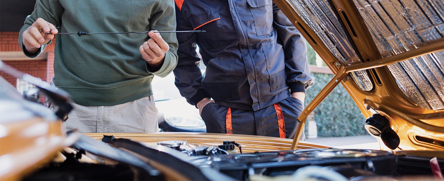 men checking car oil level