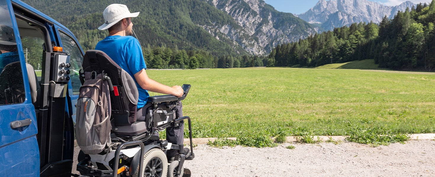 man on wheelchair looking out at mountain view
