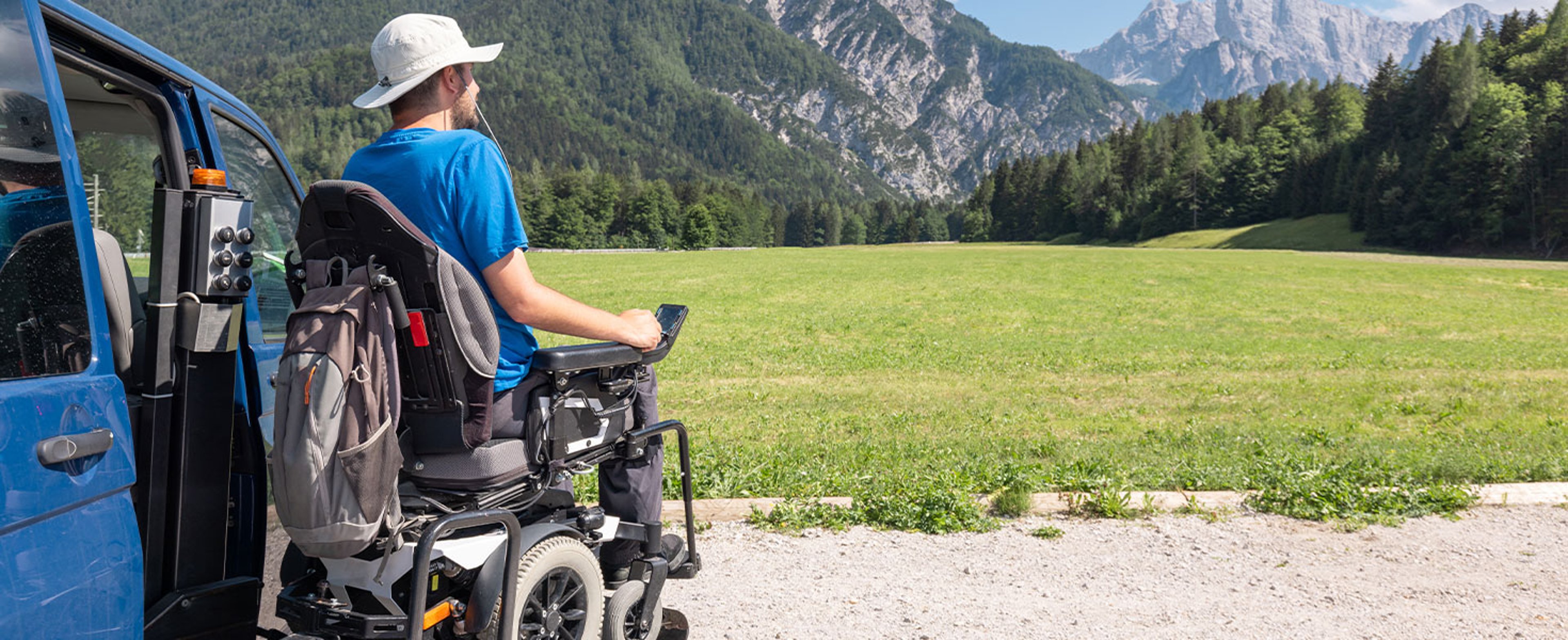 man on wheelchair looking out at mountain view