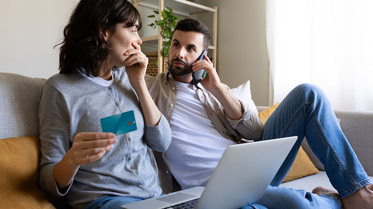 Worried couple facing online payment problems on laptop