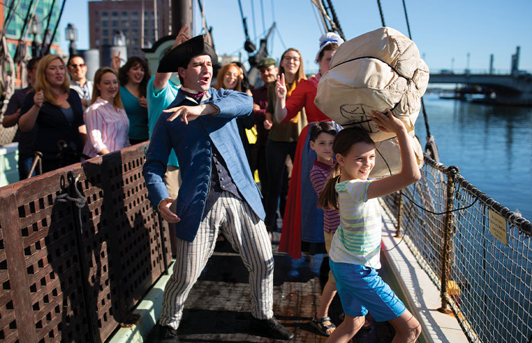 isitors participate in the ‘Destruction of the Tea’ at the Boston Tea Party Ships & Museum
