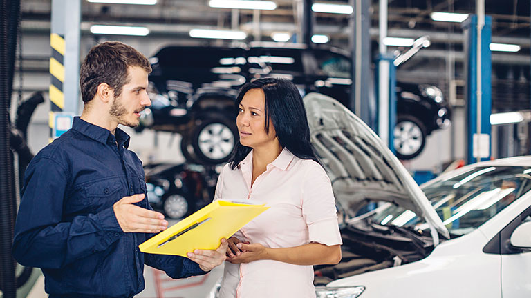 Man talking to a woman about her car. PHOTO BY MR. MUSIC/STOCK.ADOBE.COM 