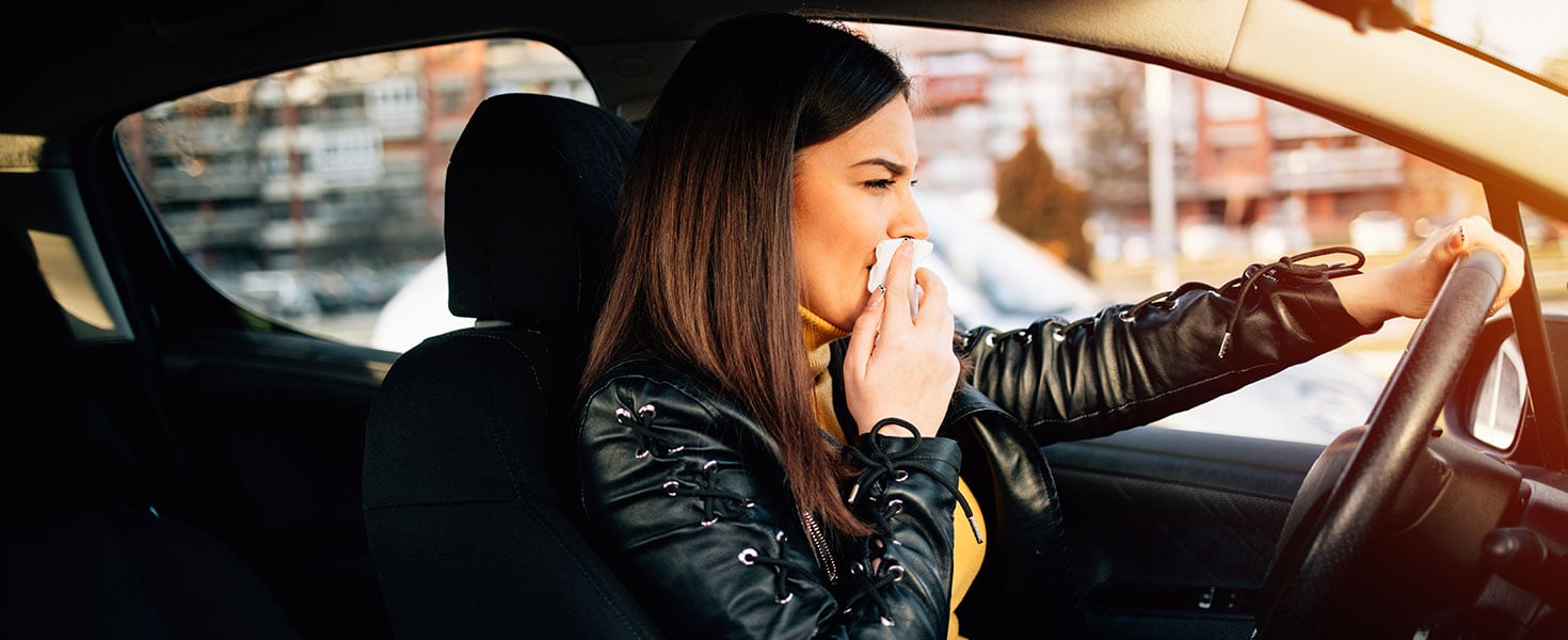 Young woman driving car with protective mask on her face; Credit:Aleksandar Pirgic