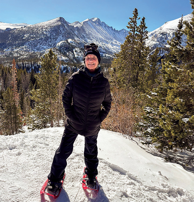 woman standing on snowy mountain with skis