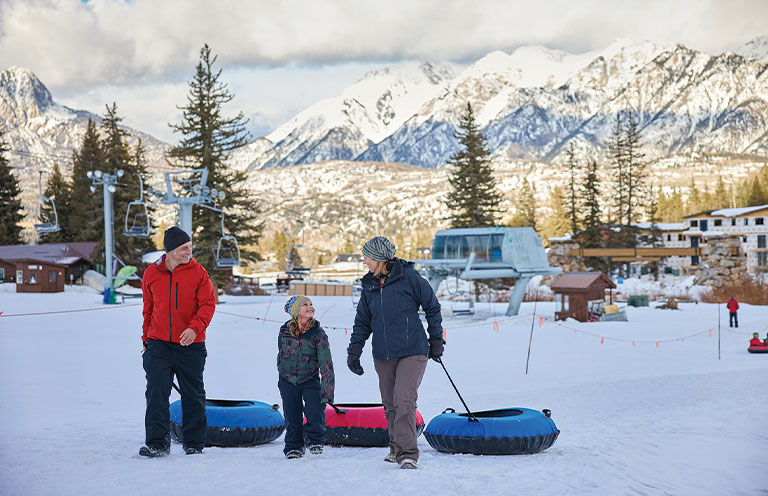 people dragging tubes for snow tubing