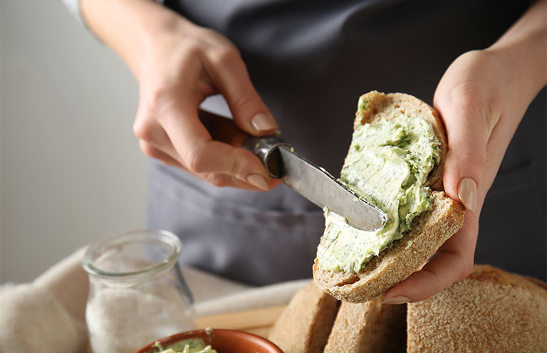 man spreading butter onto bread