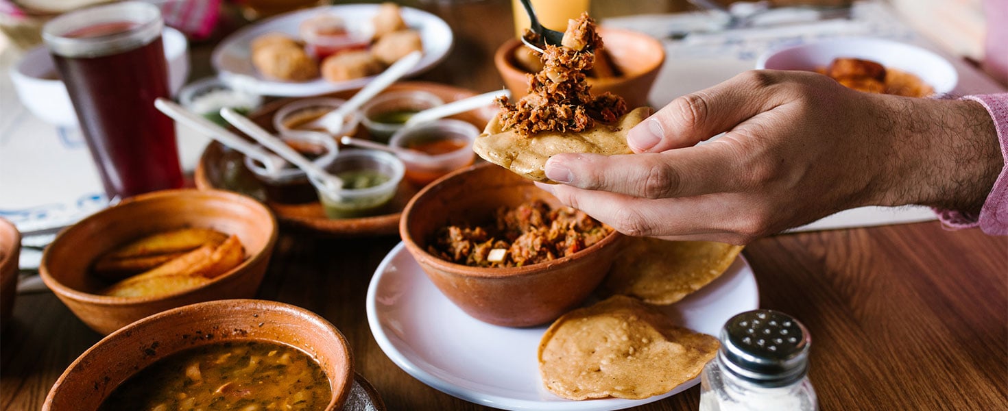 hand of man eating Mexican cuisine