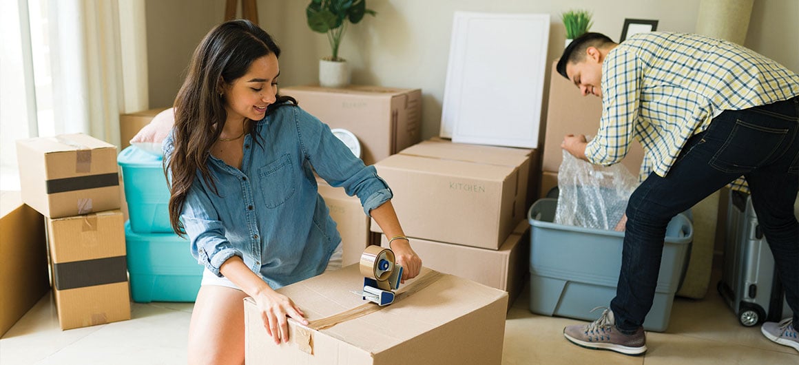 woman taping up box, moving