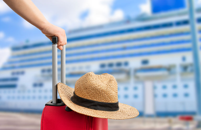 suitcase, hat, in front of cruise ship