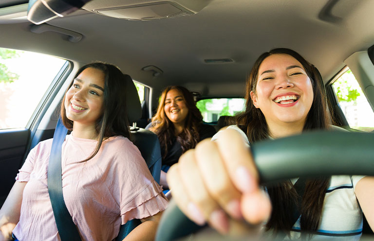 three women in car smiling
