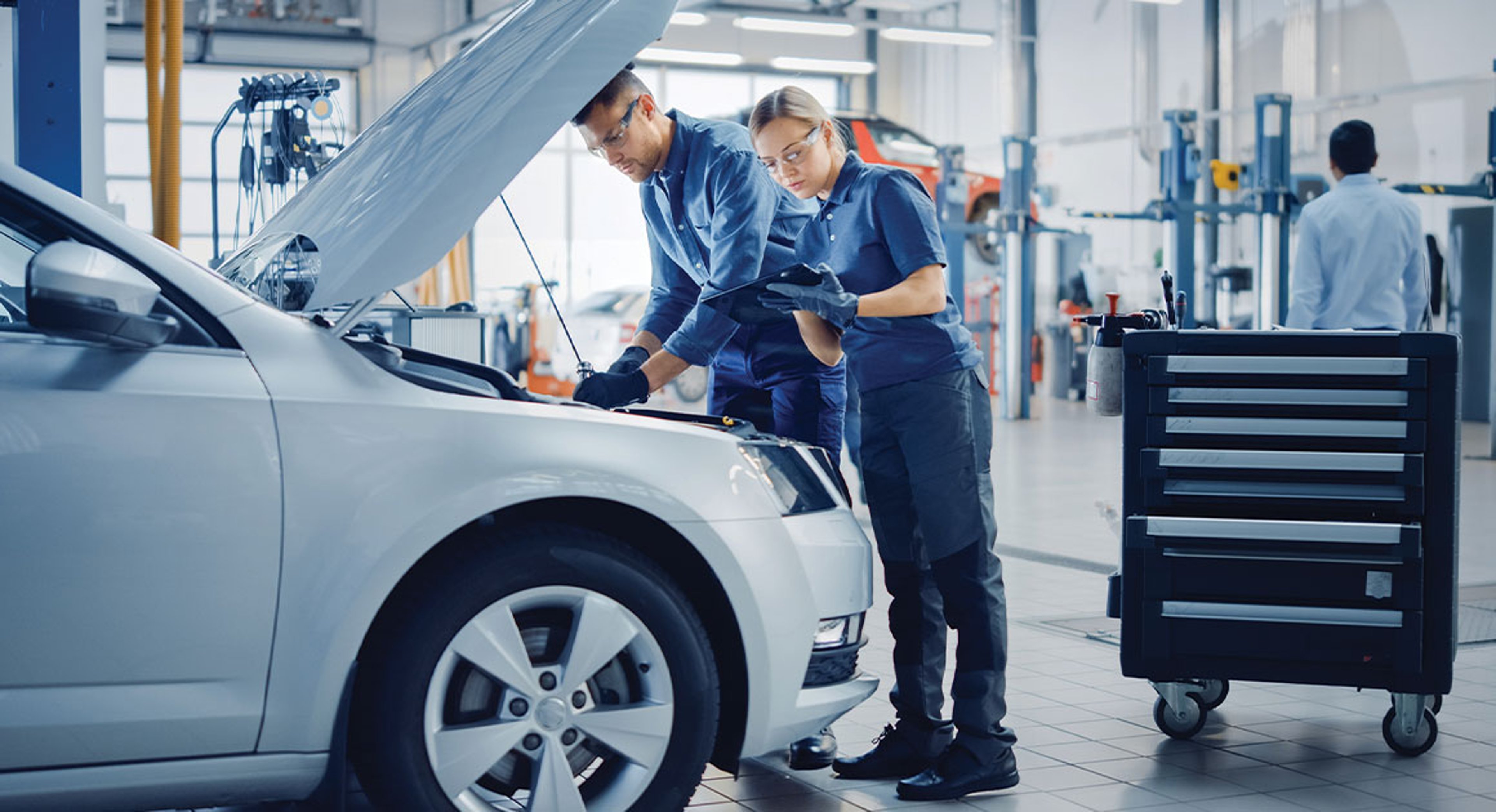 mechanics looking at car in auto shop