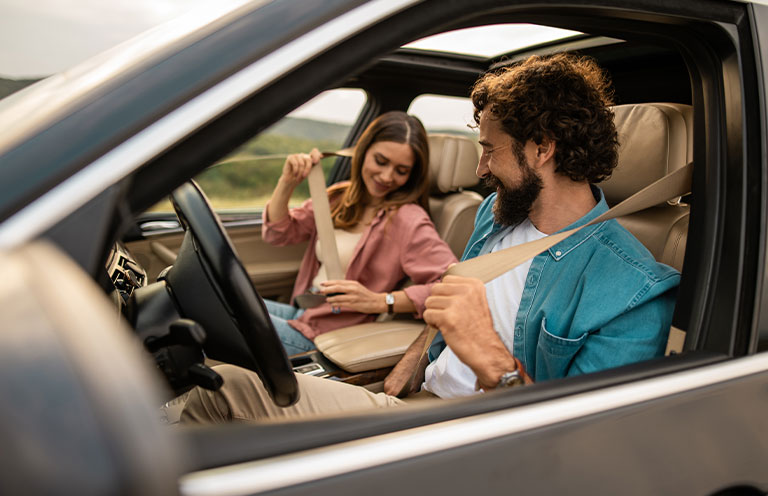 people putting on seatbelts in car