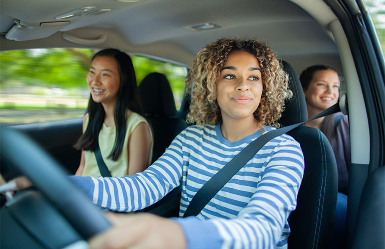 teenager driving in car with friends