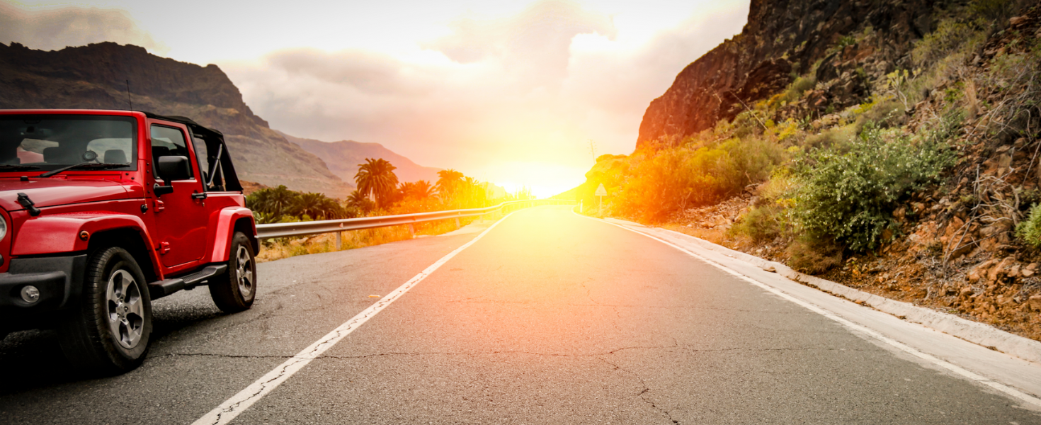 Car on road with sunset behind