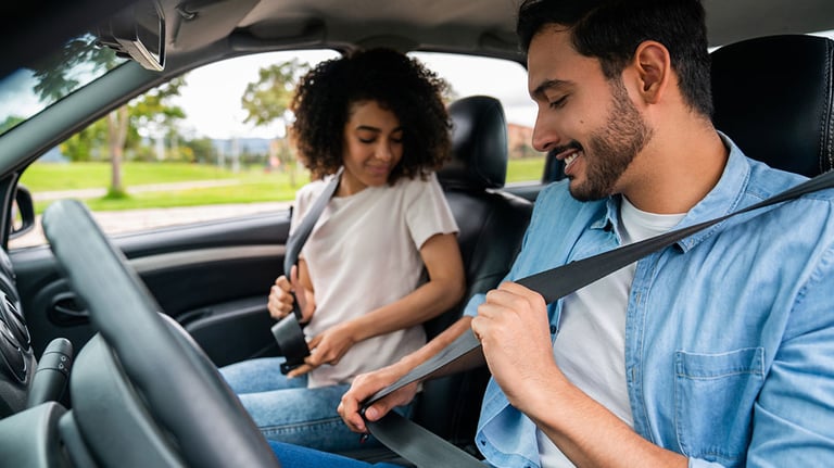 Young Latin American couple in a car fastening their seat belts - transportation concepts. Photo by Hispanolistic/iStock.com