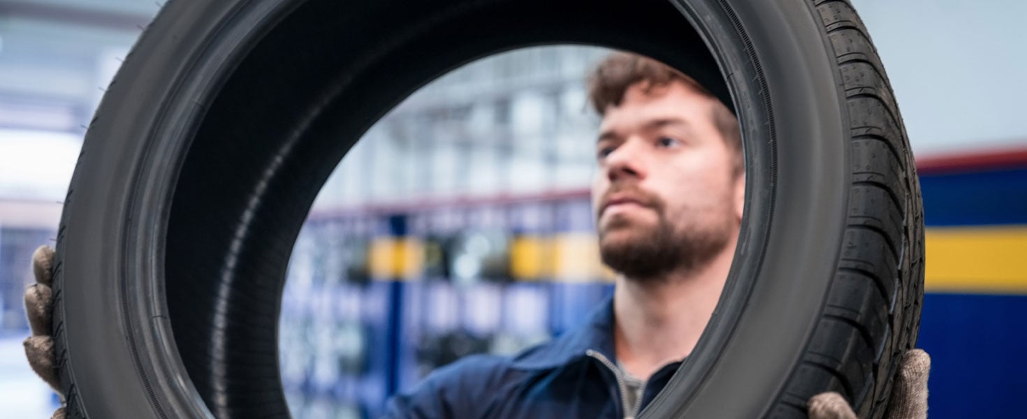 mechanic holding car tire