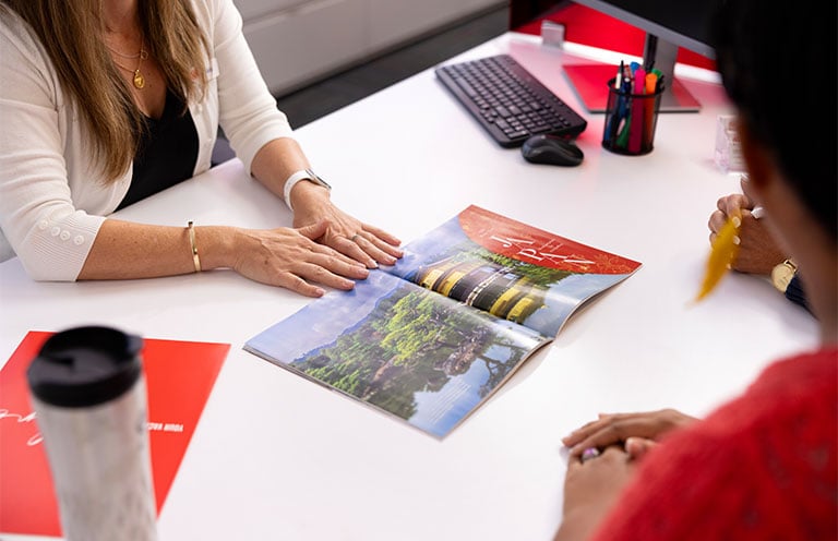 two people looking at travel magazine