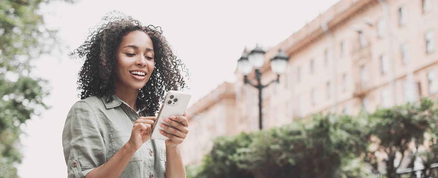 Young beautiful woman using smartphone in a city panoramic banner. Smiling student girl texting on mobile phone outdoor. Modern lifestyle, connection, casual business concept. By kite_rin