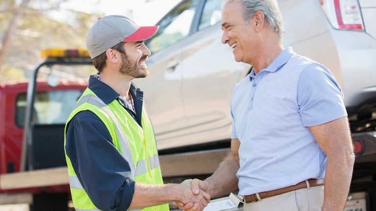 two truck driver shaking hands with man