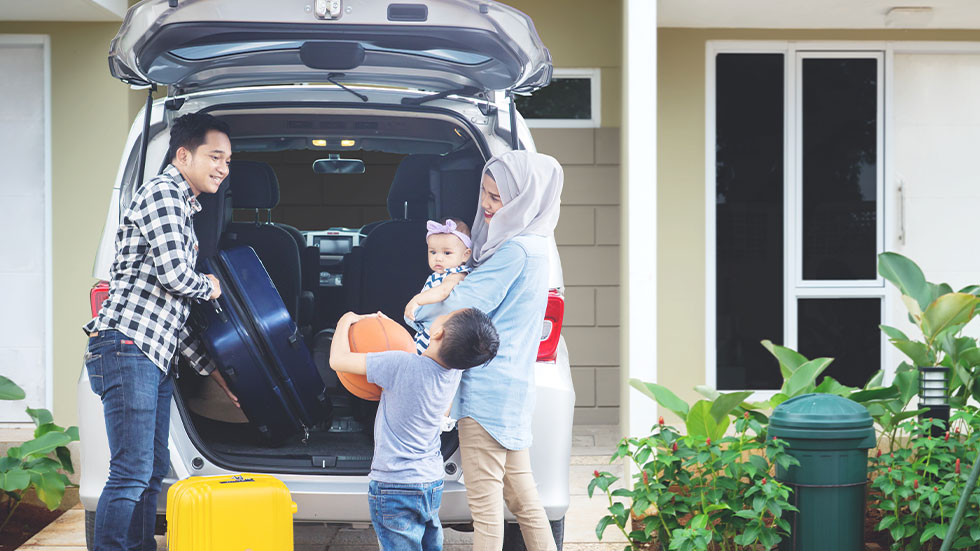 family loading car with suitcases and basketball
